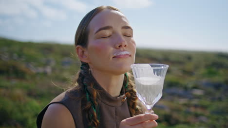 woman drinking fresh milk on outdoor picnic. closeup happy model enjoying dairy