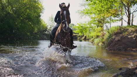 woman horse riding through a stream