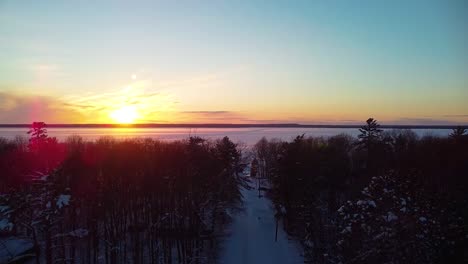 aerial winter sunset ascent over forest - michigan