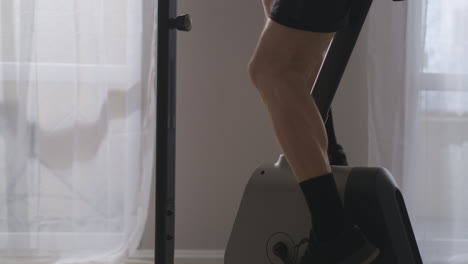 집에서 운동하는 남자 자전거 훈련 페달에 발의 클로즈업 뷰 다리의 근육을 긴장시키는 건강을 위한 심장 운동