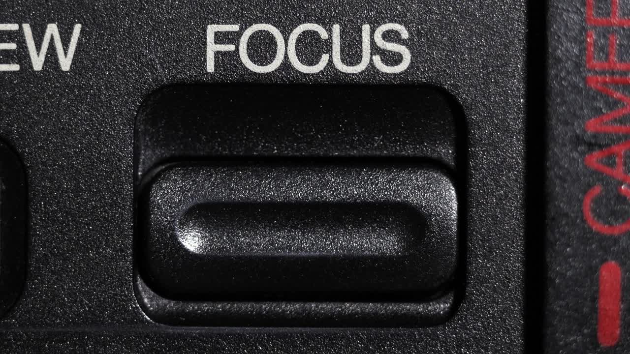 Close up of finger pressing focus button on camera, symbolizing concentration and clarity