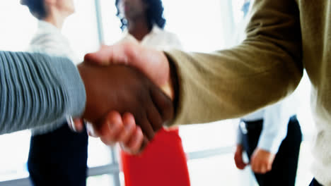 executives shaking hands in office