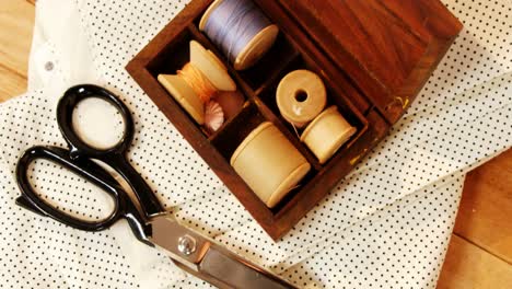 close-up of thread roll in a box and scissor