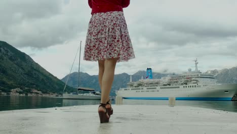 mujer caminando en un muelle junto al crucero