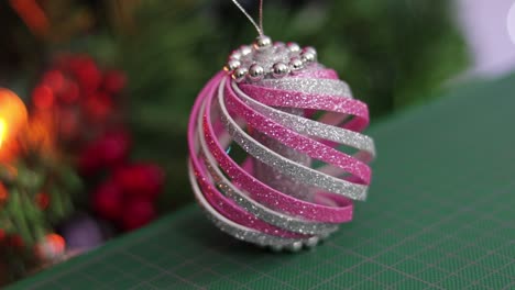 Weihnachtsschmuck-Aus-Rosa-Und-Silbernem-Glitzerschaum,-Auf-Einer-Grünen-Schneidematte