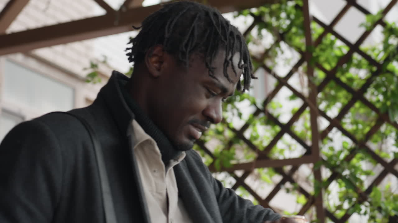 Modern youth in three layered clothes raises hand to head, checks watch, grimaces over lost time, quick steps through corridor, winter style, urgency mood emphasizing stress and countdown feeling