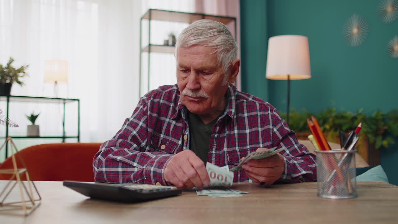 Happy grandfather man counting calculating cash money dollars planning expenses financial budget
