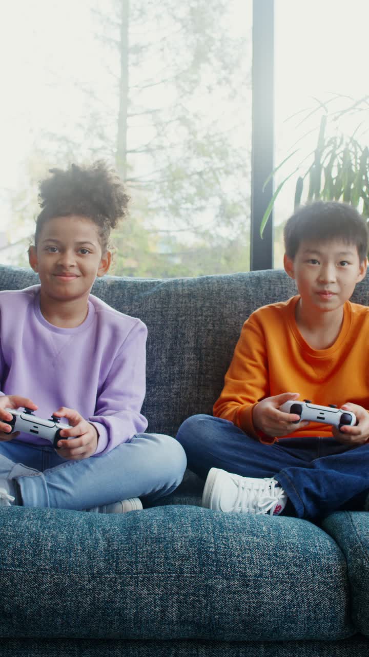 Two kids playing video games on a couch