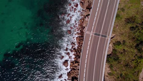 aerial view cars on sea cliff bridge, sunny day, grand pacific drive, new south wales, australia - top down drone shot