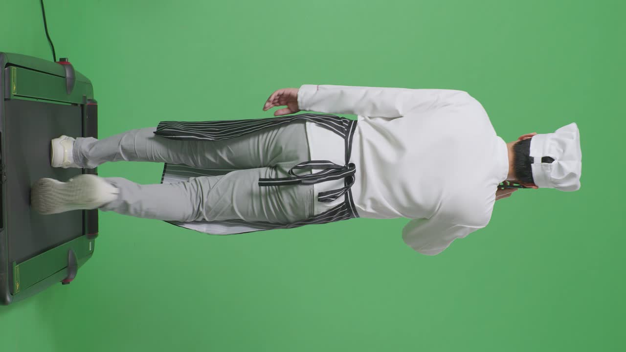 녹색 화면 배경 스튜디오에서 는 동안 스마트폰으로 이야기하는 아시아 남성 요리사