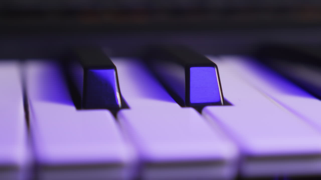 Close up of two black keys on a synthesizer keyboard, moving
