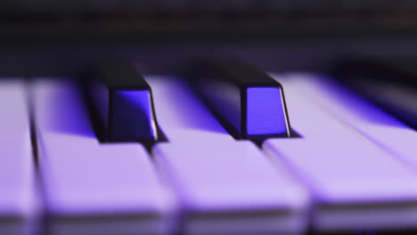 close up of two black keys on a synthesizer keyboard, moving