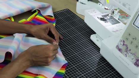 trabajador indio cosiendo ropa con máquina de coser