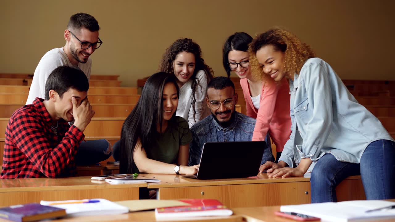 un grupo de estudiantes está participando en una videoconferencia usando una computadora portátil, están viendo la pantalla agitando las manos y hablando. tecnología moderna y concepto de educación.