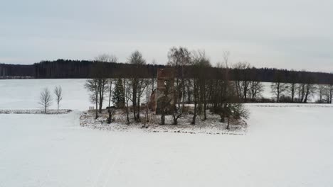 Vista-Aérea-Durante-El-Paisaje-Nevado-De-Invierno-Con-Ruinas-De-Iglesias-Abandonadas