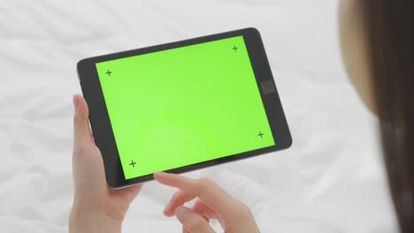 close up de mujer sosteniendo en las manos una tableta digital con pantalla verde para internet en línea, pantalla clave de croma para publicidad.