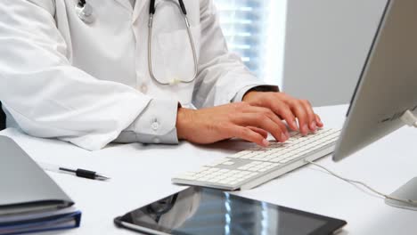 Sección-Media-Del-Médico-Escribiendo-En-El-Teclado.