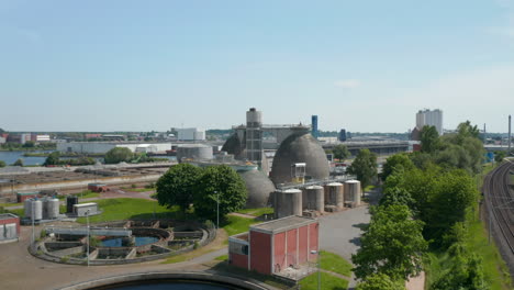 Imágenes-De-Aterrizaje-De-Tanques-De-Hormigón-Con-Bulbo-En-Un-Sitio-Industrial-Junto-A-Tanques-De-Sumidero-Circulares-En-La-Planta-De-Tratamiento-De-Aguas-Residuales.-Lübeck,-Schleswig-Holstein,-Alemania