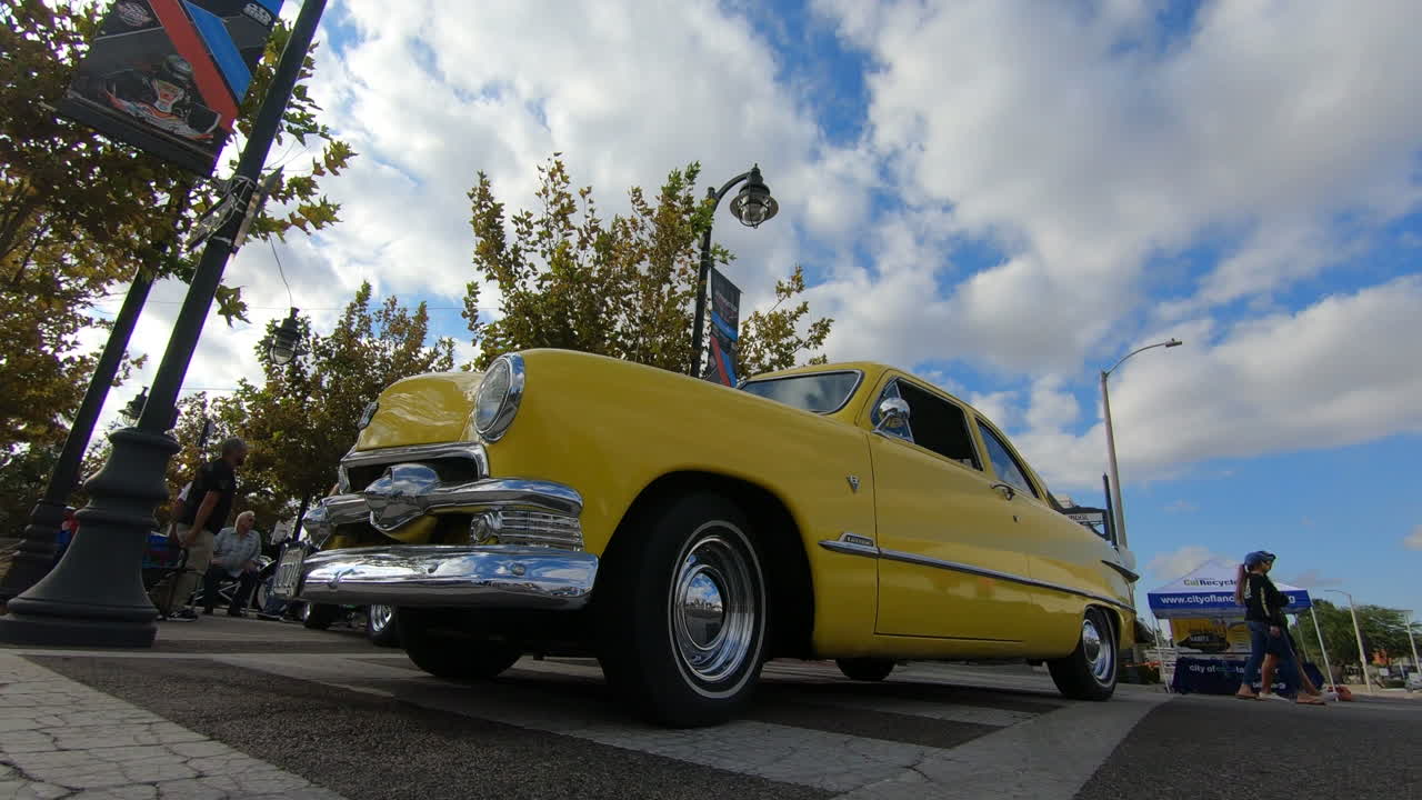 Yellow Ford Customline on display at car show, time lapse, low angle