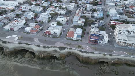 beach town in patagonia argentina, las grutas aerial street view, cliff caves formation by sea erosion, travel and tourism latin america