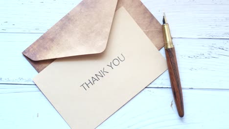 thank you message and envelope on wooden table