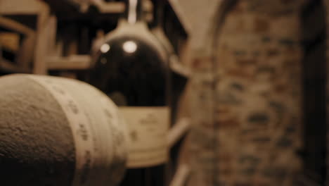close-up of dusty wine bottles in an ancient cellar