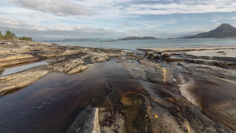 a shallow stream flows through the sandy beach and connects with the sea