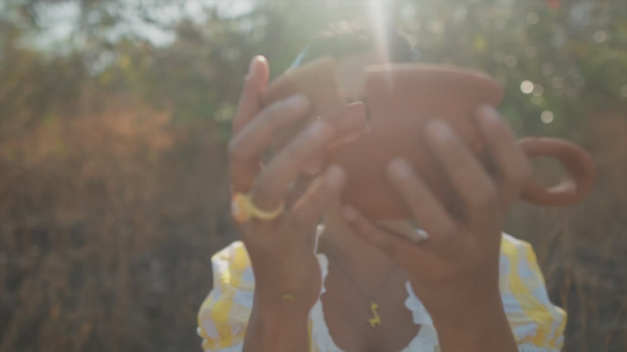 una hermosa mujer india que sostiene un fragmento de cerámica roto vuelve a juntar las piezas para crear una olla unificada