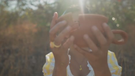 una hermosa mujer india que sostiene un fragmento de cerámica roto vuelve a juntar las piezas para crear una olla unificada