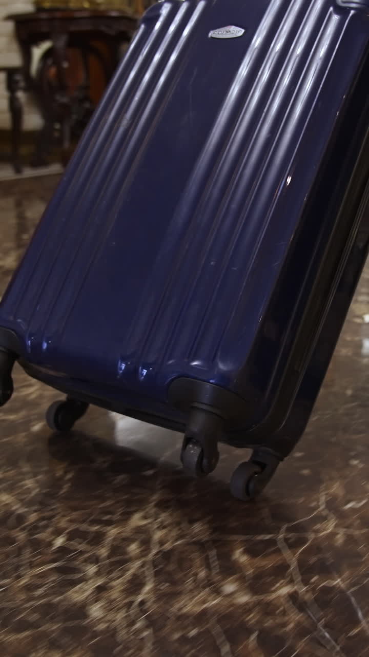 Traveler arriving to the hotel. Businessman with suitcase walking to the hotel lobby. Vertical video