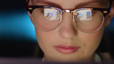 retrato de cerca hermosa mujer de negocios trabajando hasta tarde usando una tableta navegando por datos de gráficos financieros mirando la información en la pantalla usando gafas