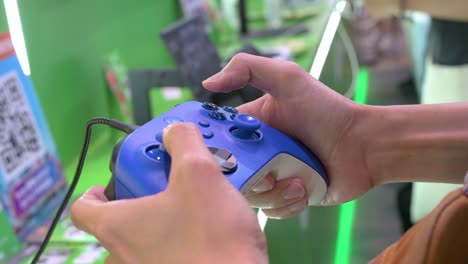 a visitor plays a videogame using a controller