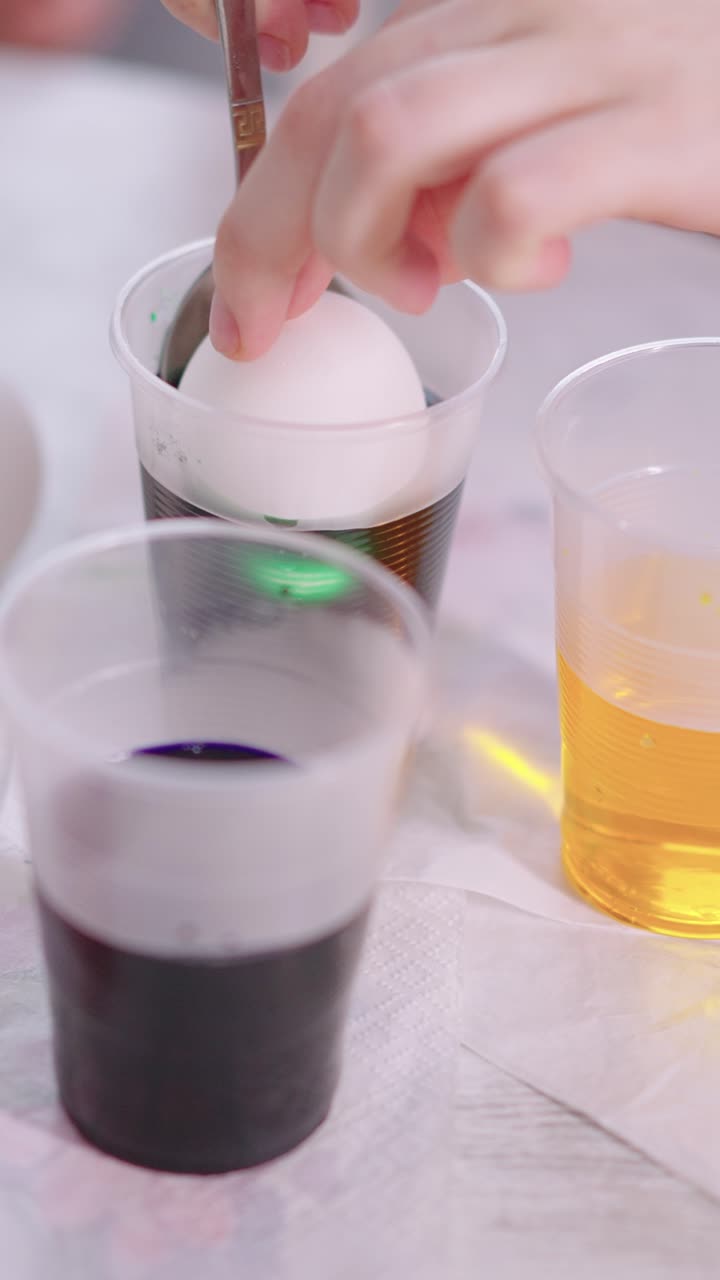 Tingere un uovo di Pasqua bianco di verde con un cucchiaio
