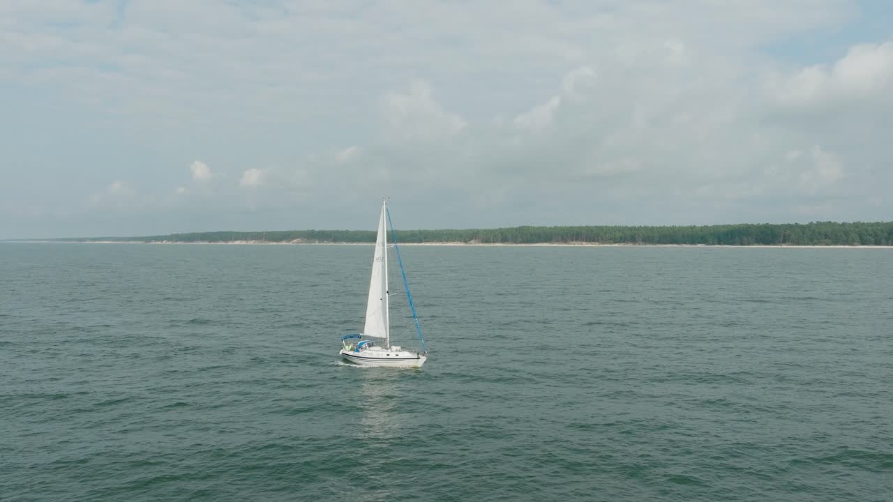 vista aérea estableciendo de un velero blanco en el mar báltico tranquilo, yate de vela blanco en medio del mar sin límites, día soleado de verano, amplia órbita hecho tiro