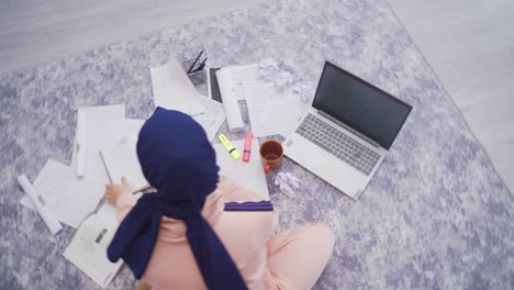 Muslim-teenage-girl-in-hijab-is-studying.-Time-lapse.