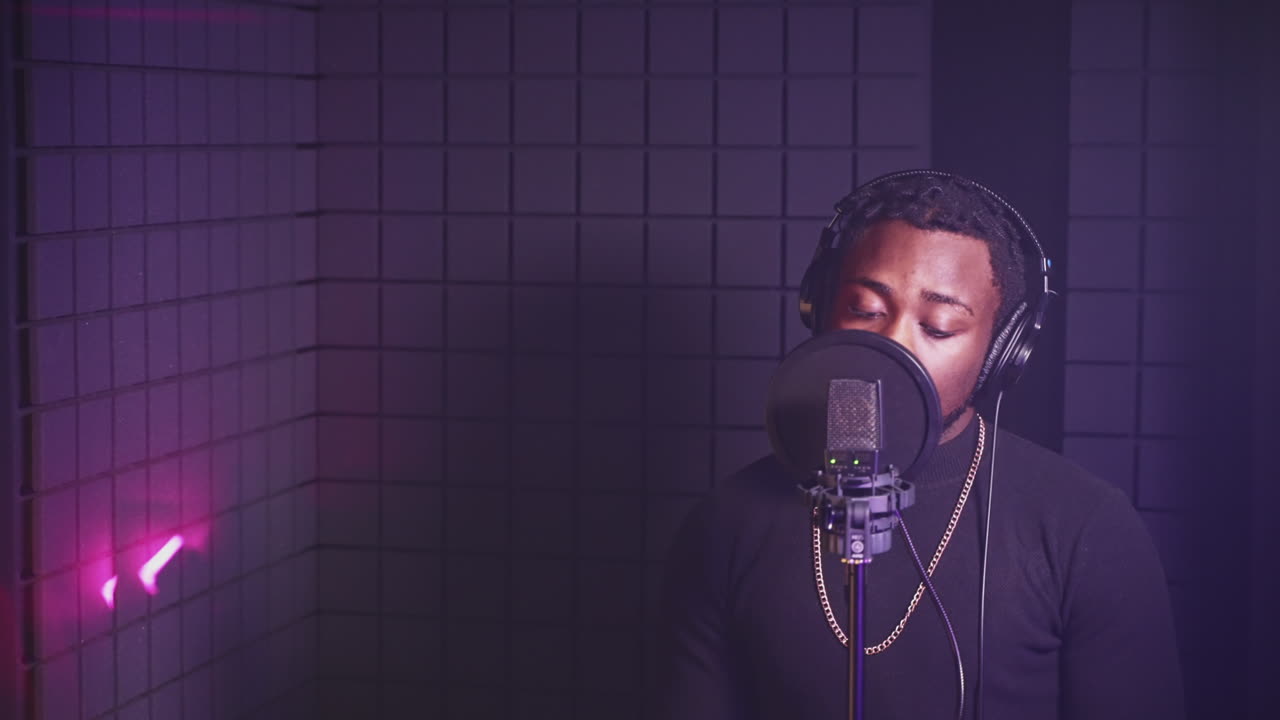 hombre cantando en el micrófono en el estudio de grabación