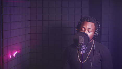 man singing into microphone in recording studio