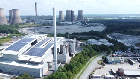 instalación solar limpia en la azotea en la vista aérea de un edificio de oficinas moderno con una central eléctrica de carbón en la órbita de fondo revelada a la derecha