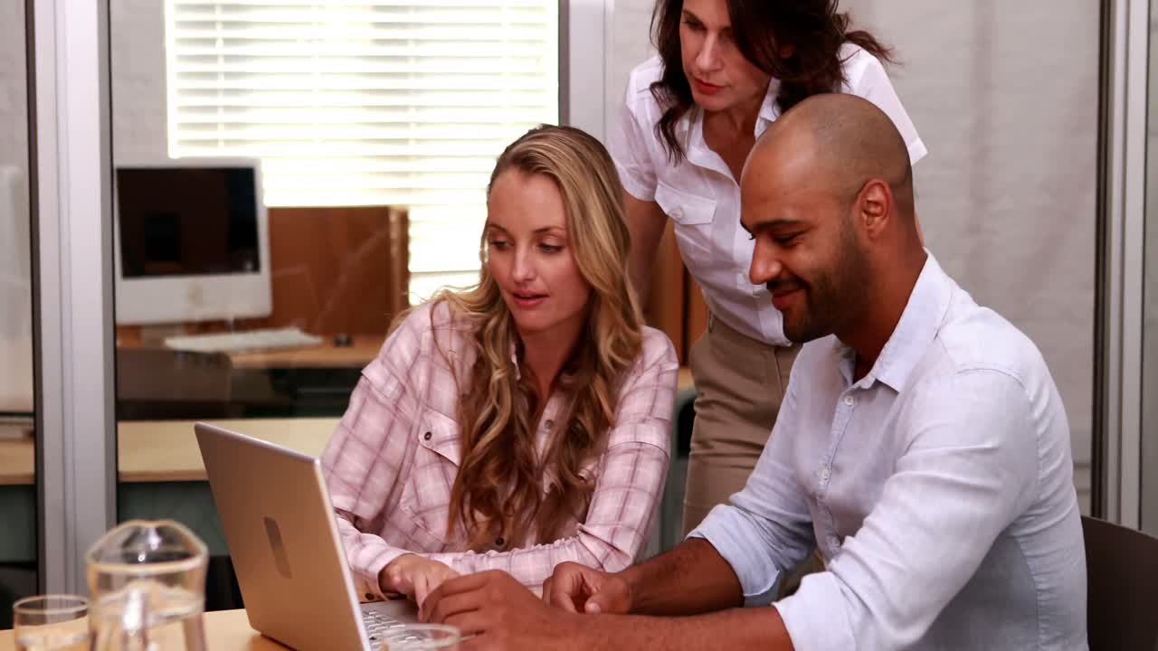 Casual business team having a meeting using laptop