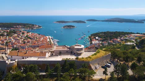 panorama of a coastal town with many houses with red roofs, surrounded by the sea and mountains