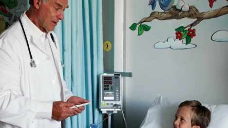 médico masculino usando tableta digital durante la visita en la sala