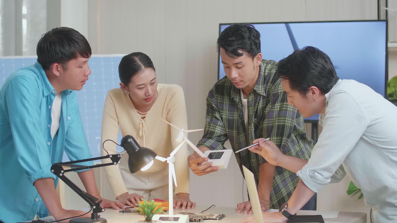 아시아 엔지니어 그룹이 사무실에서 풍력 터빈에 대한 회의를 하고 있습니다.