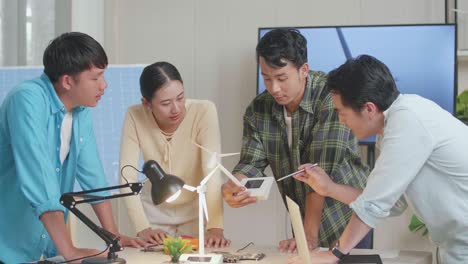 asian engineers group having a meeting about the wind turbine at the office