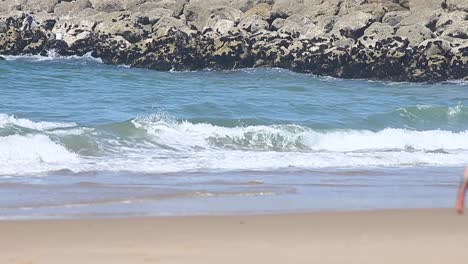 Mann-Geht-Mit-Einer-Kamera-In-Der-Hand-Am-Strand-Spazieren,-Unscharf