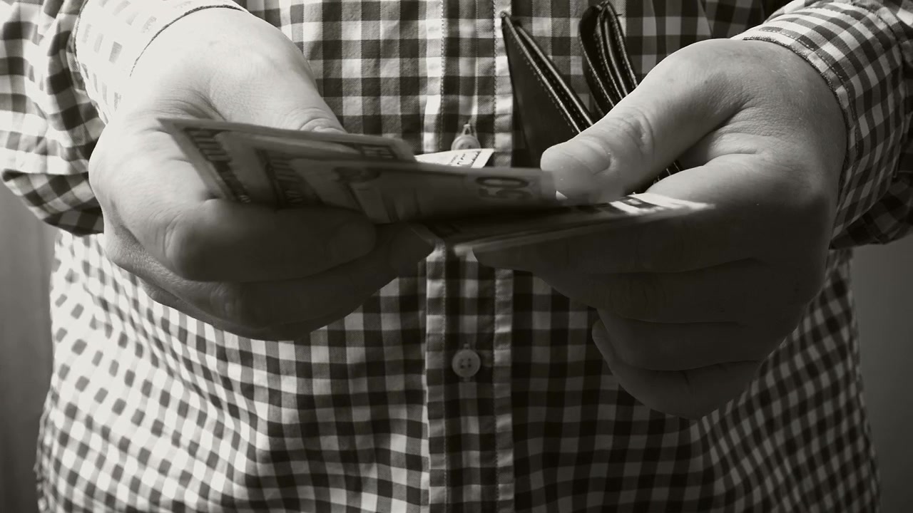 Un uomo ricalcola i dollari nel suo portafoglio