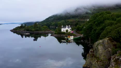 toma de un dron que comienza en una casa de pescado que revela lentamente loch carron con nubes bajas, en las tierras altas escocesas
