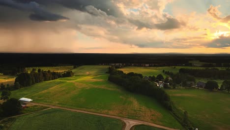 panoramic view of rural landscape with green fields and cloudy sky near hjo, sweden - aerial shot