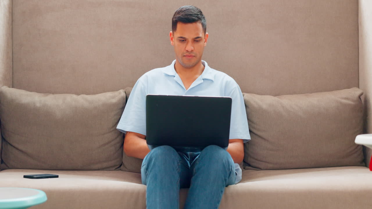 소파에서 노트북으로 일하는 남자