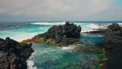 Toma-En-Cámara-Lenta-De-Olas-Del-Océano-Agitadas-Aplastando-Contra-La-Costa-Rocosa-Volcánica