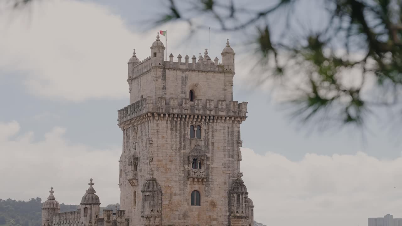 historic stone tower framed by pine needles in soft daylight lisbon portugal